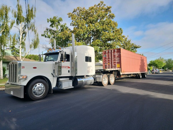 white truck with container on landoll trailer.JPG