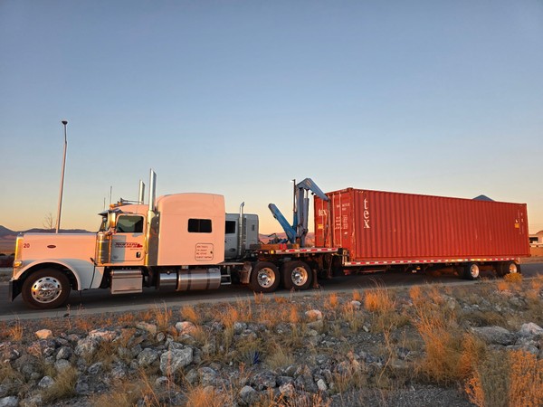 sideloader placing container onto truck chassis