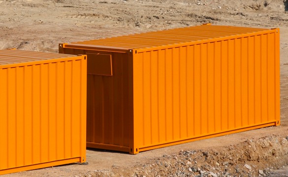 orange shipping containers on dirt