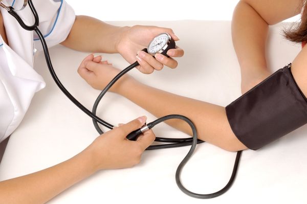 Image of a healthcare professional taking blood pressure of a patient Health Screenings