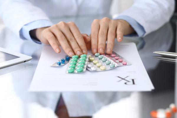 Image of the healthcare professional handing medications and prescription Medication Therapy Management