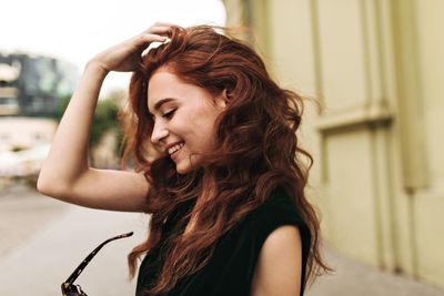 curly-woman-putting-off-sunglasses-and-smiling-2024-09-23-23-20-22-utc.jpg