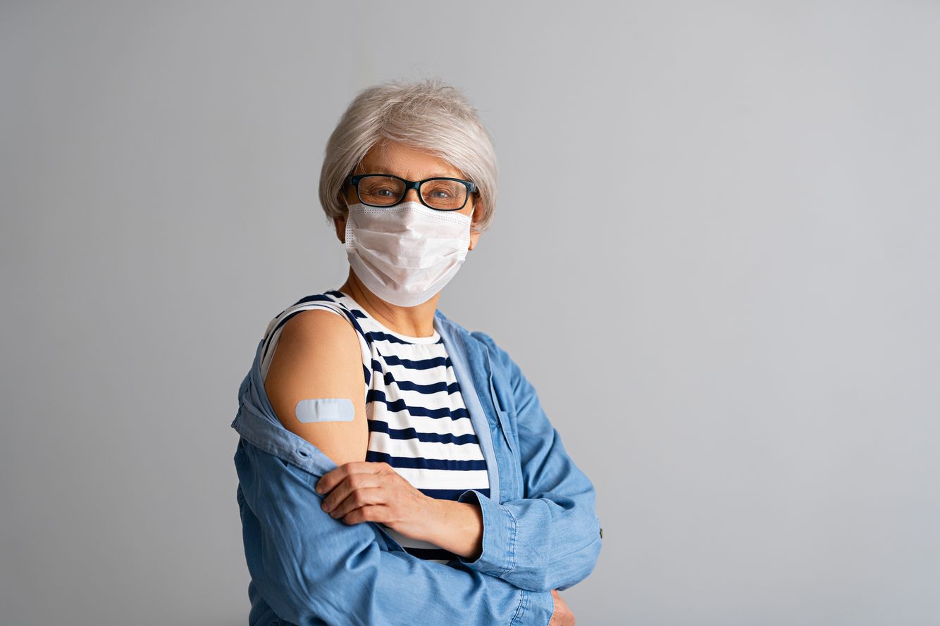 Woman with a bandaid on her upper arm immunizations