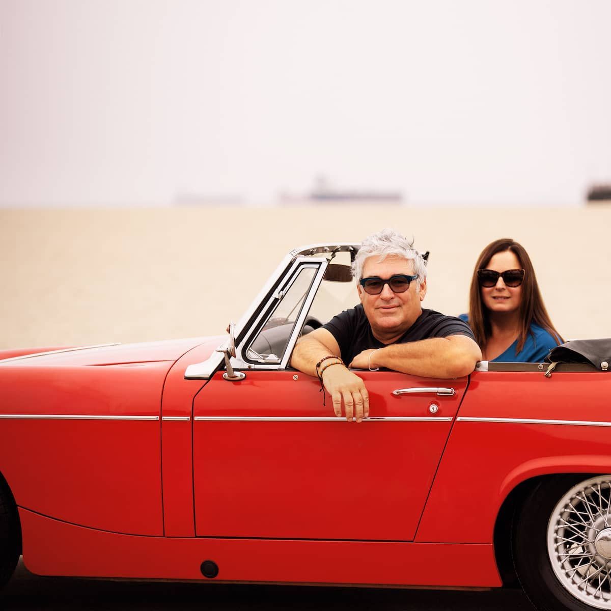 Jour majesty sitting in a MG Midget  at the beach.