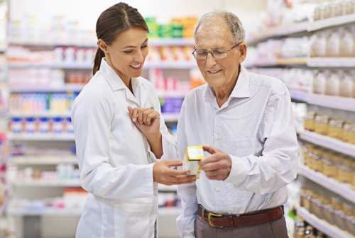 Pharmacist with customer looking at medication