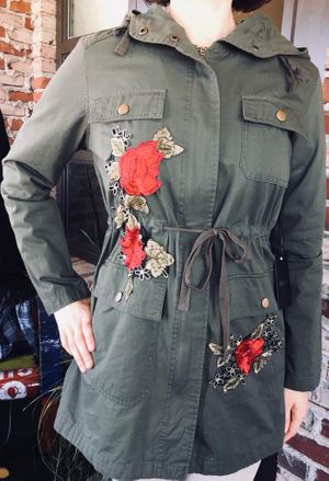 Mannequin wearing a dark green jacket with red flowers on it Harvest Drug and Gift shop items