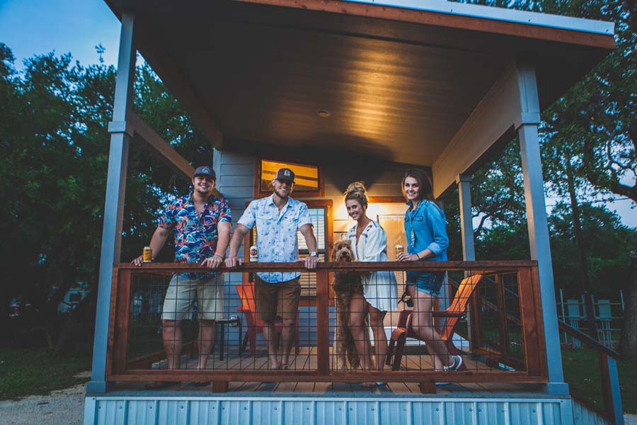 Friends on tiny house large porch enjoying the evening glamping near gruene