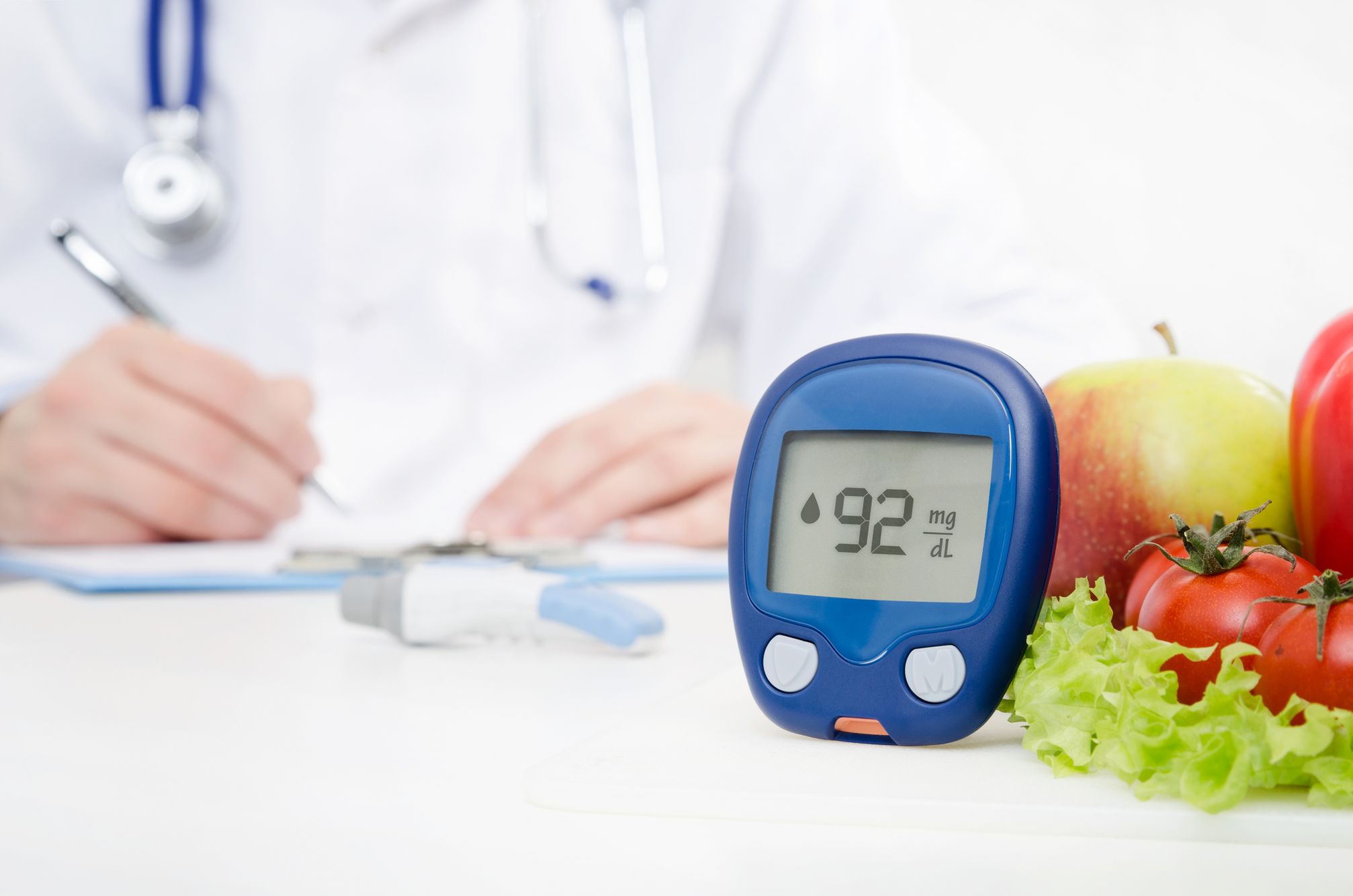 blue glucose monitor leaning on an assortments of fruits and vegetables with the torso of a doctor Diabetes Management