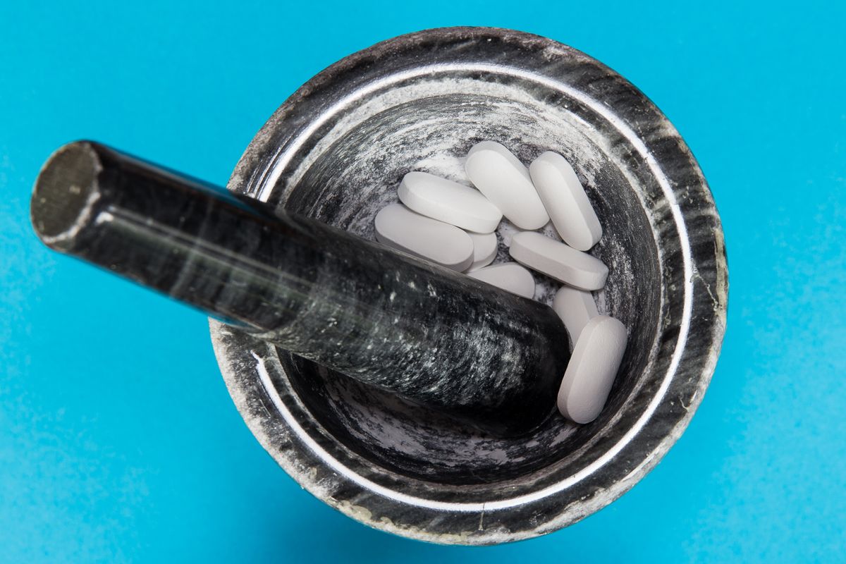 Mortar and pestle with a blue background Compounding