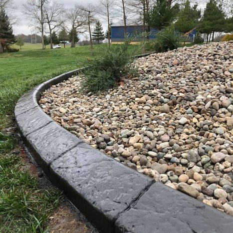 Curved black stone landscape border with decorative river rock
