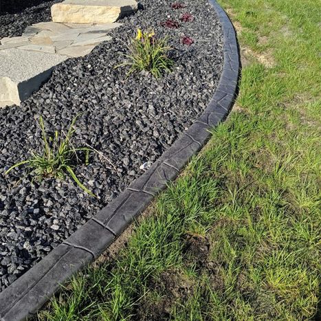 Black decorative landscape Border beside lawn and gravel bed