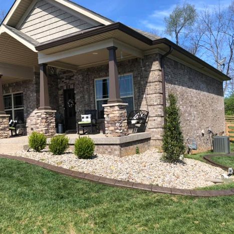 Decorative stone landscape border with white rock around front porch