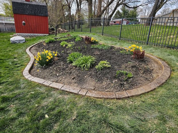 Decorative stone landscape border with mulch and flowering plants