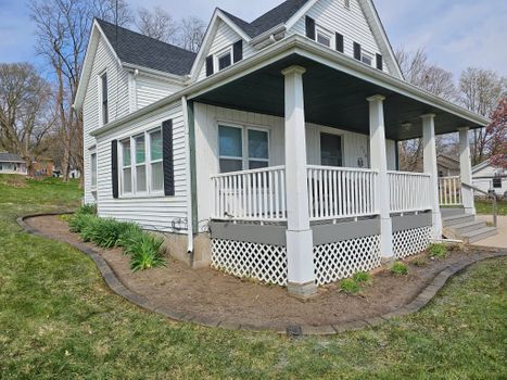 Decorative stone landscape border along home foundation and porch