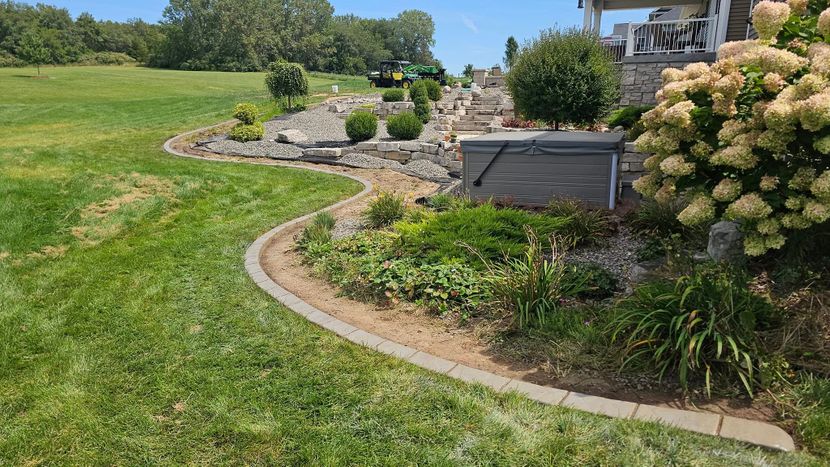 Decorative curved stone landscape border with plants and retaining wall