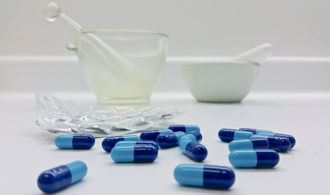 Mortar and pestle sitting behind medication Compounding