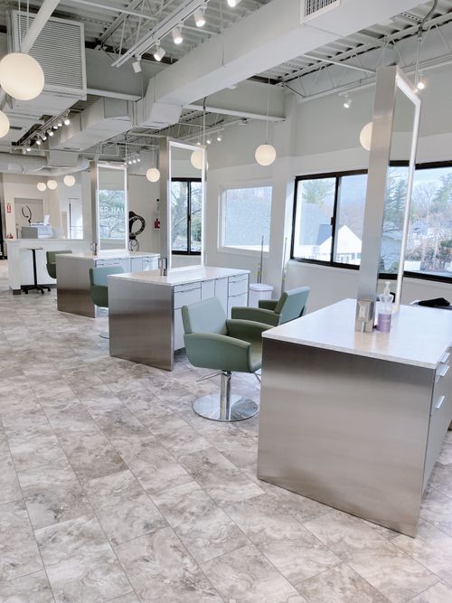 Bright and modern interior of Alexander Hair Creatives in Derry NH, featuring sleek styling stations, natural light, and a relaxing, professional atmosphere that defines the AHC guest experience. Alexander Hair Creatives Salon Interior Derry NH