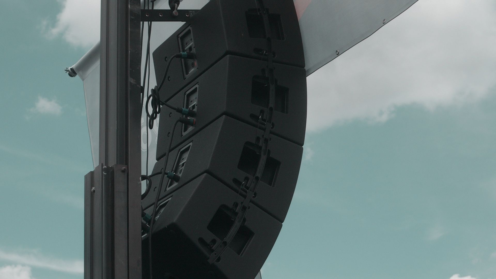 Hanging speaker on a stage at an outdoor event