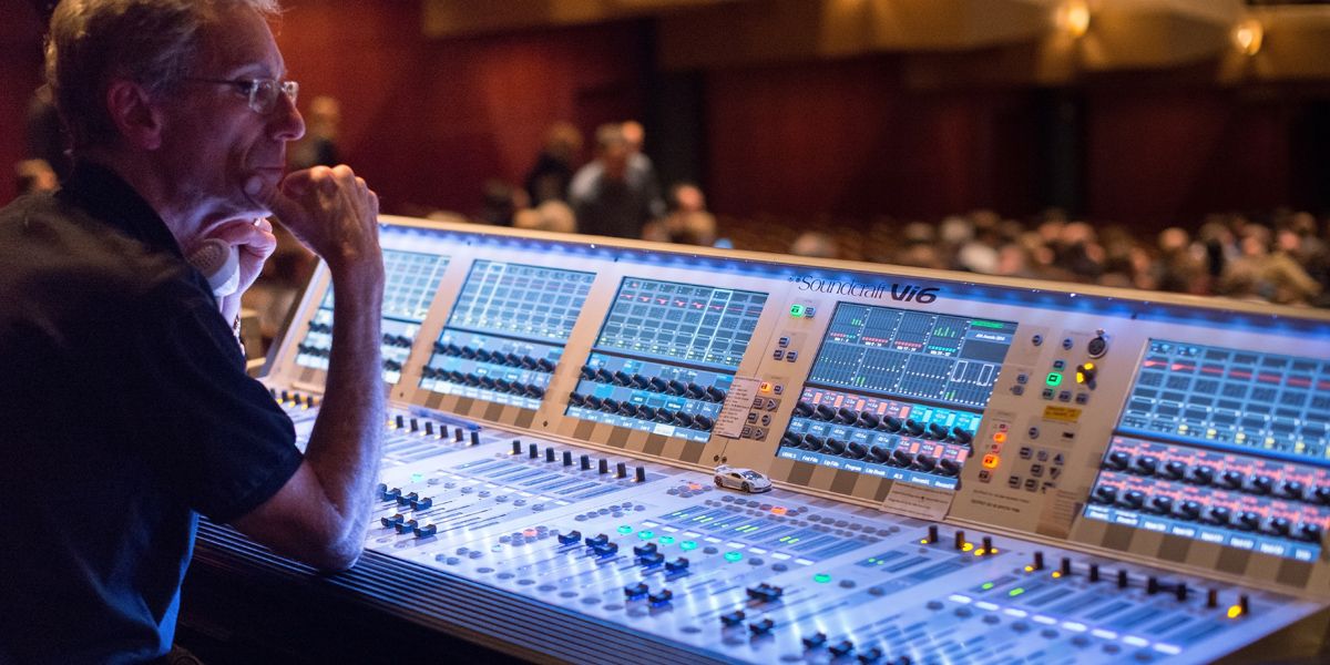 Audio Technician sitting at a Soundcraft  audio mixer at event 