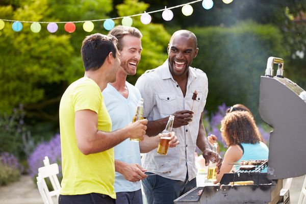 Men laughing and grilling outside Men's Health