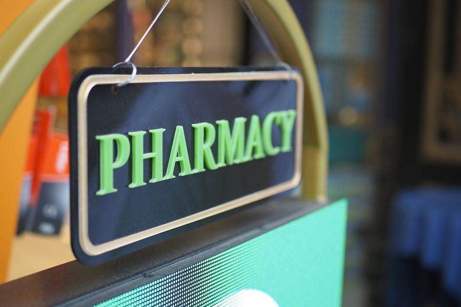 Pharmacy sign sitting in the doorway. About Us