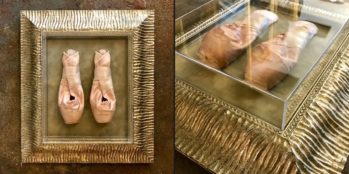 an acrylic box preserves a pair of tiny pointe shoes Child's ballet shoes