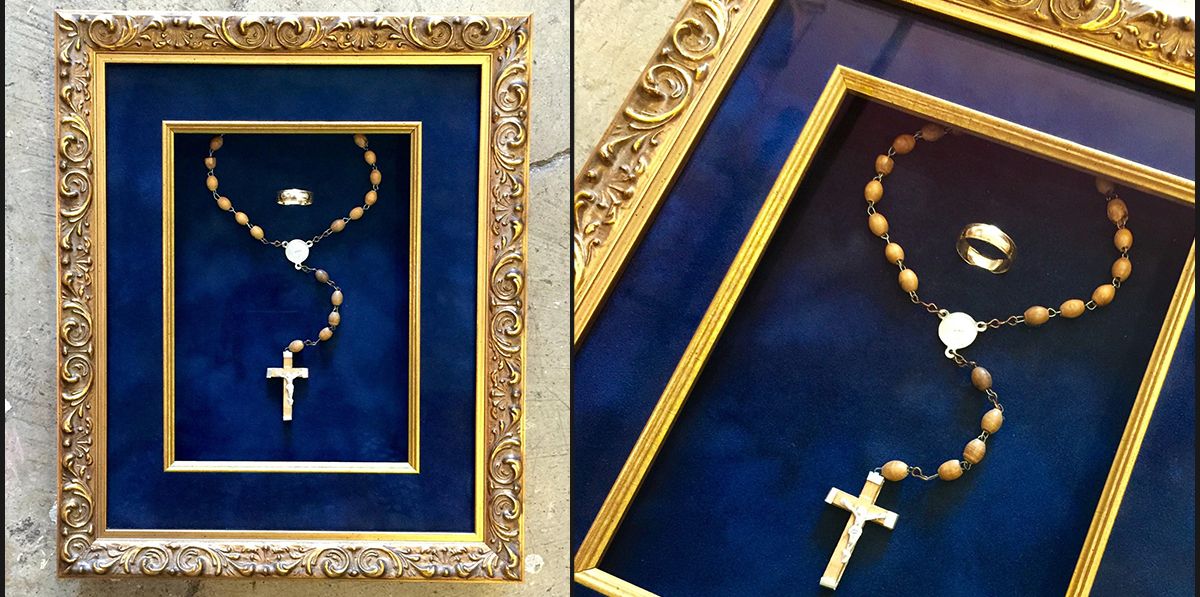 A rosary and wedding band framed in royal blue suede with a gold frame and gold fillet, transform these items into a loving memory  Personal Effects