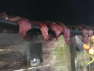 jerky meat cooking over outdoor kitchen stove