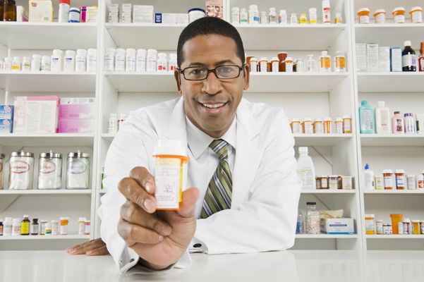 A pharmacist holds up a prescription Pharmacy
