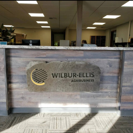 Custom Engraved Interior Boulder Sign for Commercial Office Reception Featuring Wilbur-Ellis Agribusiness Branding