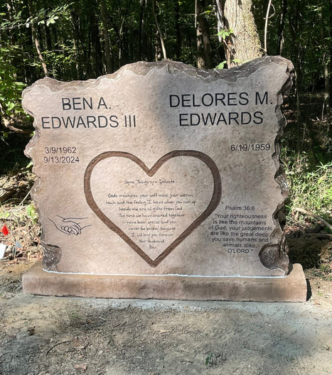 Affordable etched rock double headstone with heart engraving in wooded cemetery setting