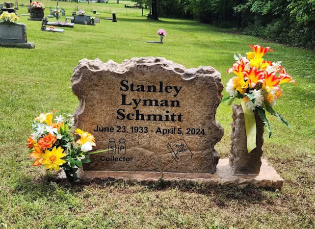 Affordable brown stone boulder headstone with engraved name and flowers