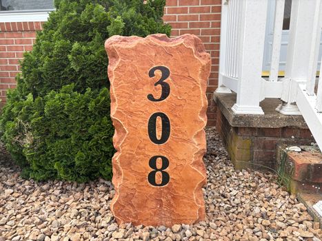 Tall engraved stone address marker displaying the house number 308 in black numbers beside a brick home in Bridgewater, VA, created by Angelopulos StoneCraft