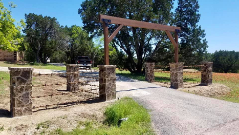 Decorative stone entryway columns and gate by Boulder Designs