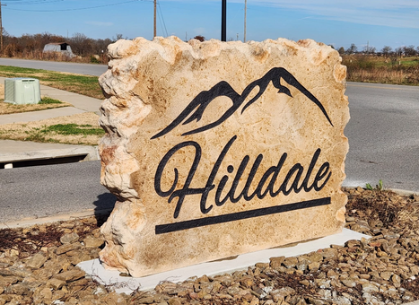 Custom carved stone commercial entrance sign for Hilldale neighborhood with mountain logo