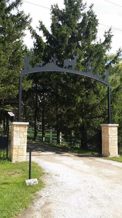 Custom crafted stone entryway arch with wildlife silhouette by Boulder Designs