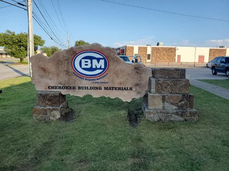 Etched rock and boulder business monument sign for building materials company