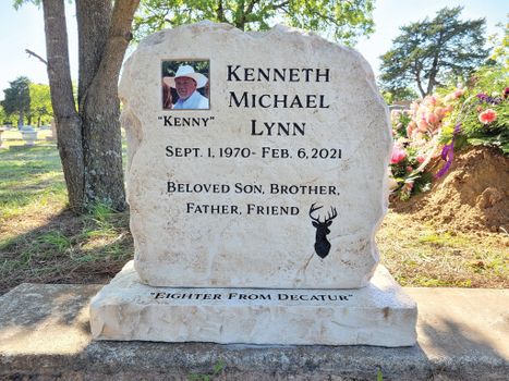 Affordable light tan stone boulder headstone with engraved name and portrait