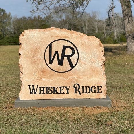 Custom carved stone commercial entrance sign for Whiskey Ridge with WR logo