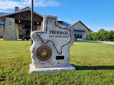Texas shaped boulder house sign with Marine Corps emblem and established date