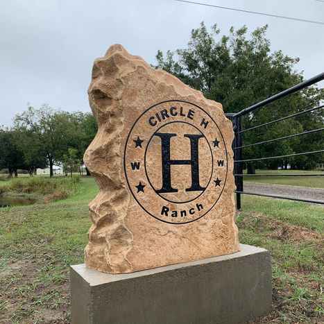 Engraved Circle H Ranch boulder sign with circular brand logo