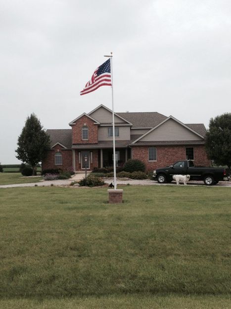 Residential flagpole with decorative stone base by Boulder Designs