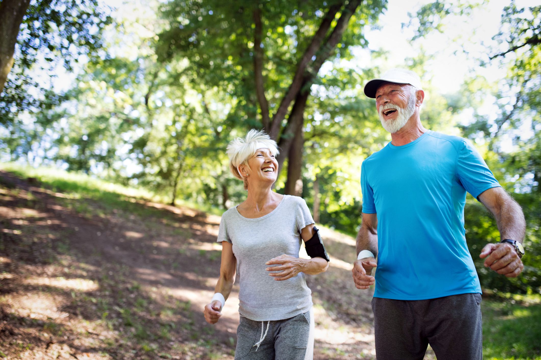 Image of an older couple jogging in a park. Medicare Open Enrollment