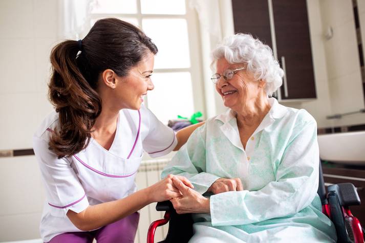 An elderly woman being assisted by a nurse Long Term Care