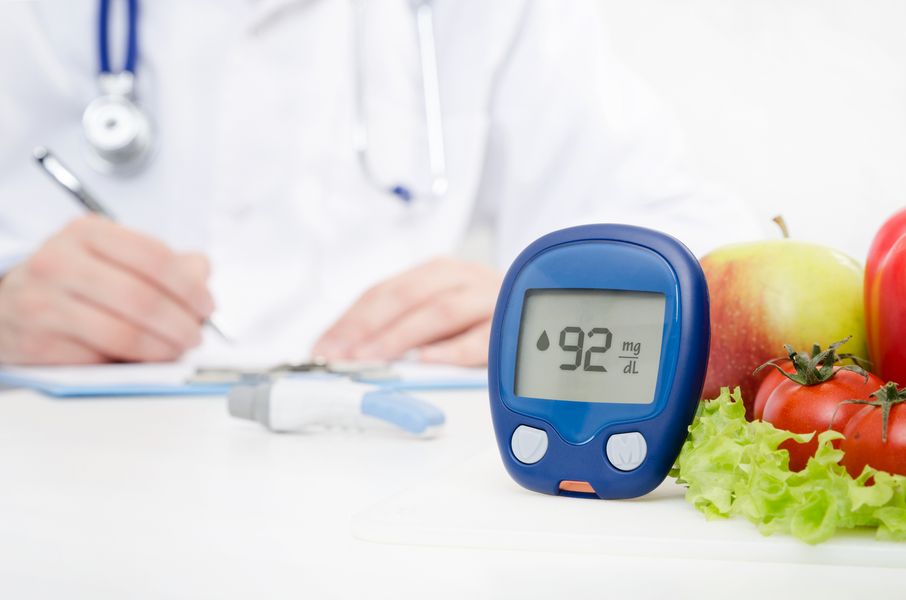 Image of a glucometer beside fruits and vegetables with a healthcare professional writing a prescription in the background Diabetes Specialized Care Center