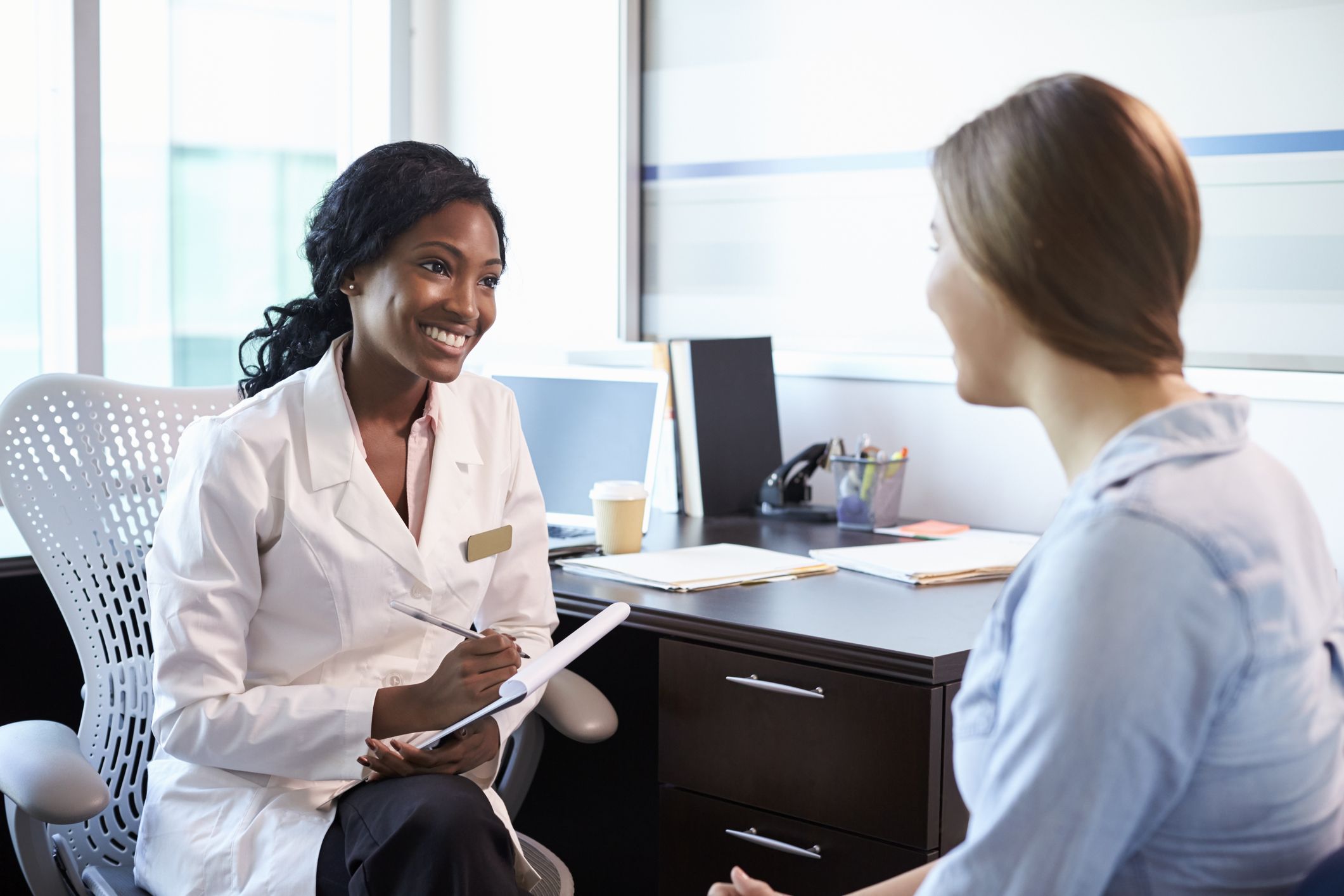 Female pharmacist talking to a female patient Women's Health