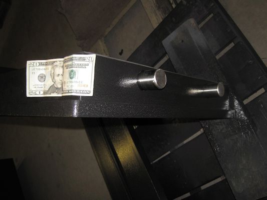 an opened escape hatch with a 20 dollar bill on top of it.