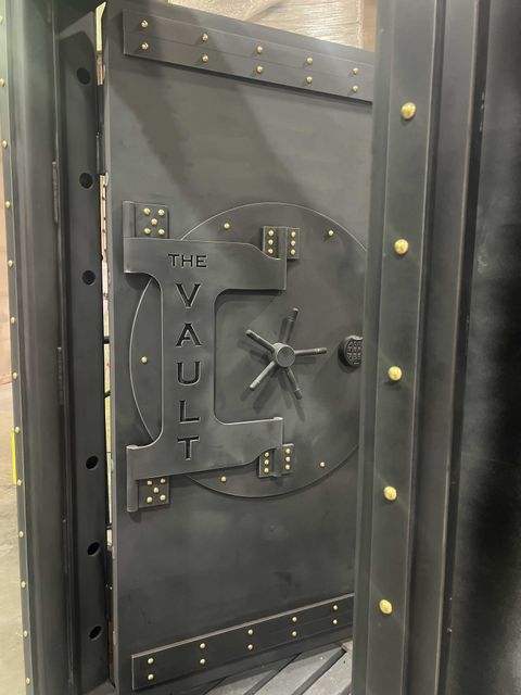 A heavy steel vault with custom engraving reading the vault opened up.