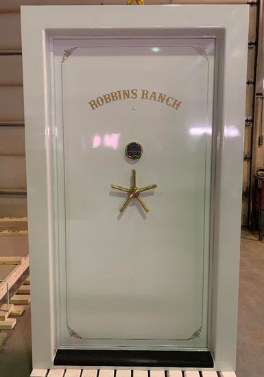 White Gloss finished vault door with Robbins Rank text across the front and a gold handle. White Gloss finished vault door with Robbins Rank text across the front and a gold handle.