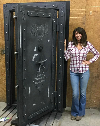 A woman in a flannel shirt presenting an open Deer Antler Steampunk Vault Door